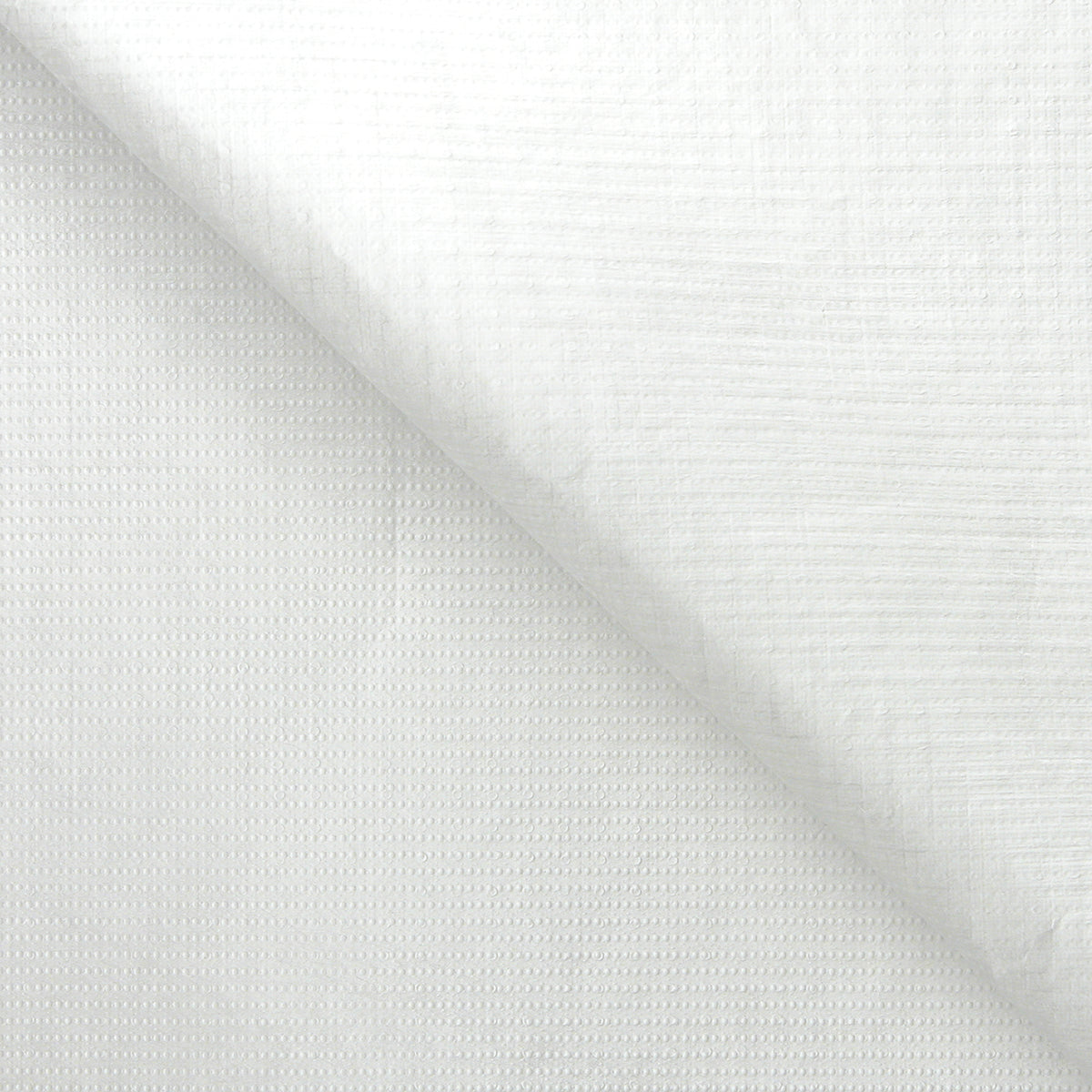 A sheet of white Tyvek material folded diagonally across itself against a white background. The surface shows a subtle woven texture with a faint grid and dotted pattern pressed into it. The lightweight sheet has a soft matte finish, with gentle creasing where it folds.
