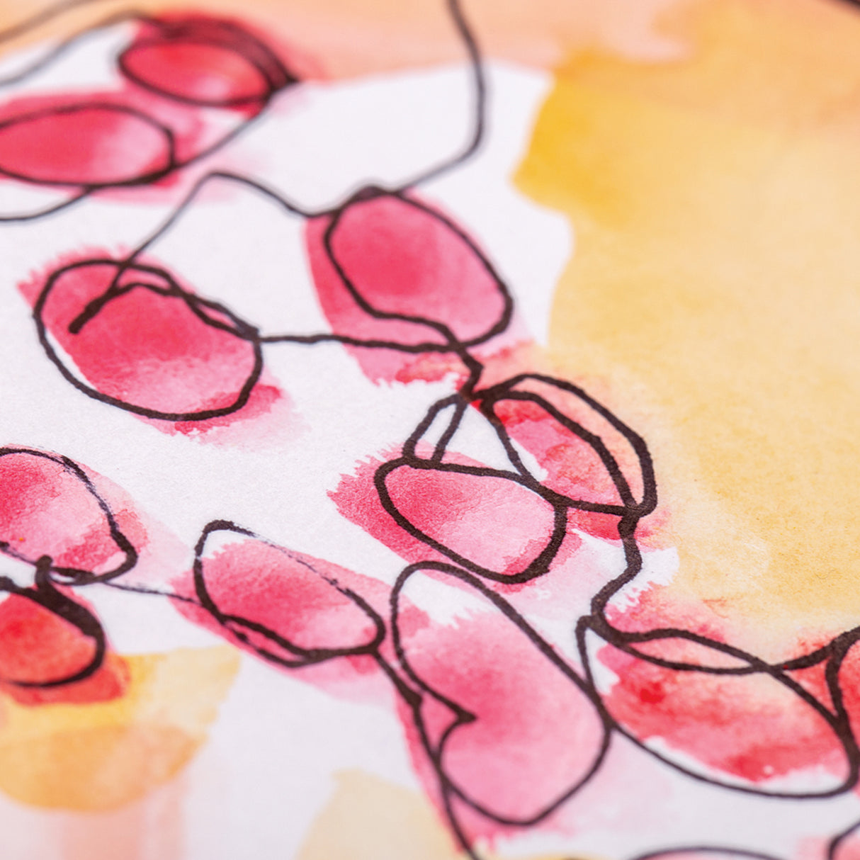 Close-up of artwork drawn with a black permanent pen on white paper, showing loose black linework over red and yellow watercolour washes to demonstrate ink clarity over painted surfaces.