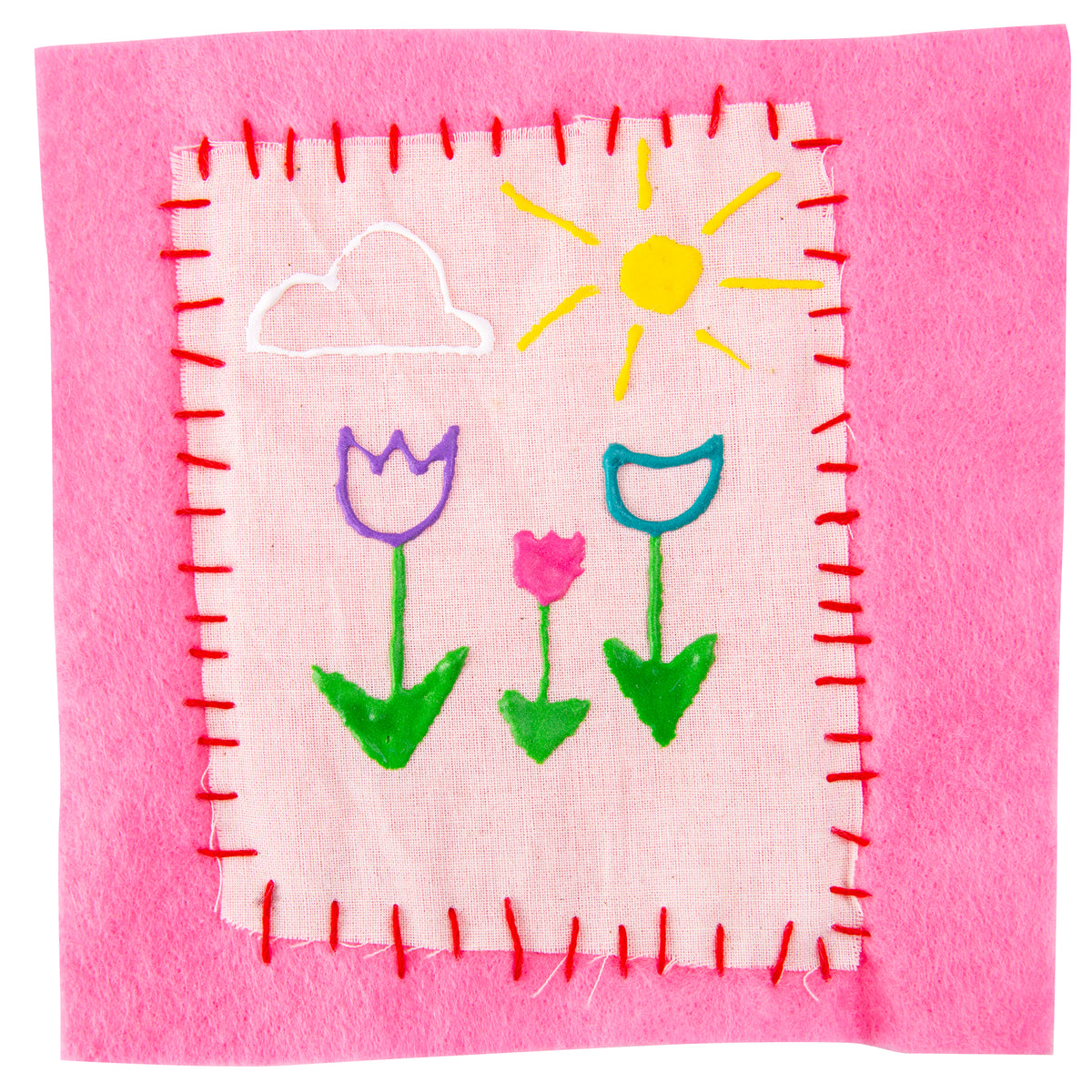 A square of pale pink fabric, hand-stitched with red thread onto a pink felt backing, decorated in raised puffy paint. The design shows a white cloud, a yellow sun with radiating rays, and three flowers in purple, pink and teal with green stems and leaves.
