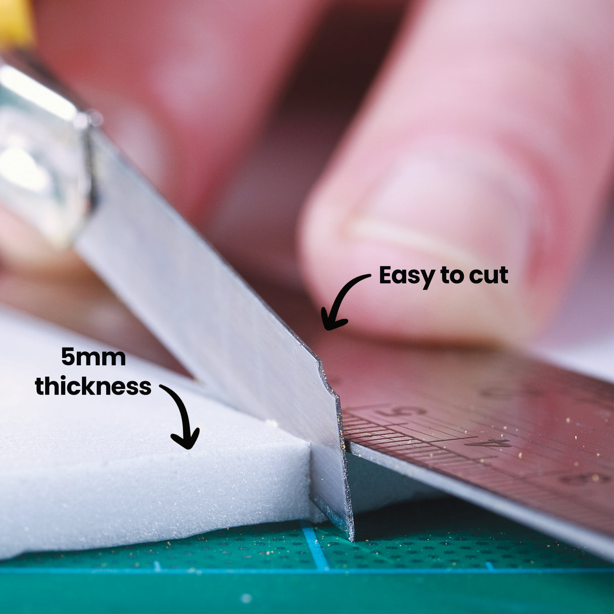 Close-up of white foam being cut with scissors on a green cutting mat. On-image text reads “Easy to cut” and “5mm thickness”. The foam shows a soft, slightly porous interior where the blade slices through.