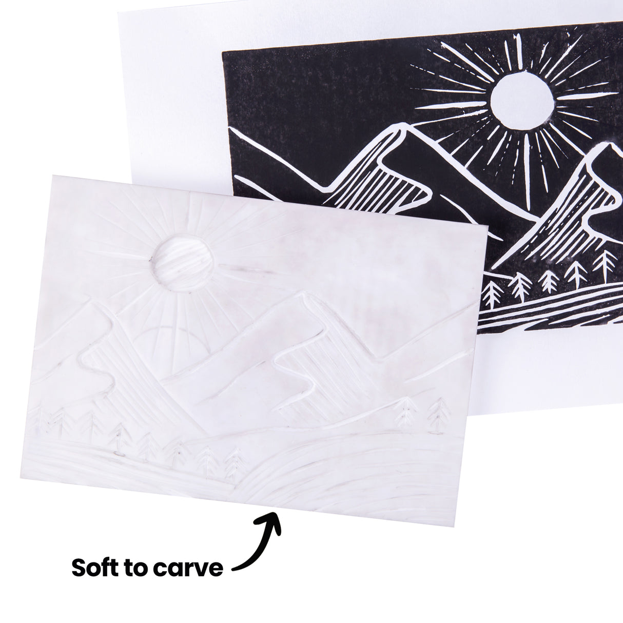 White carving block showing a landscape design carved into the surface, placed in front of a black printed version featuring mountains, trees and a sun. Black on-image text reads “Soft to carve” with an arrow pointing to the block.