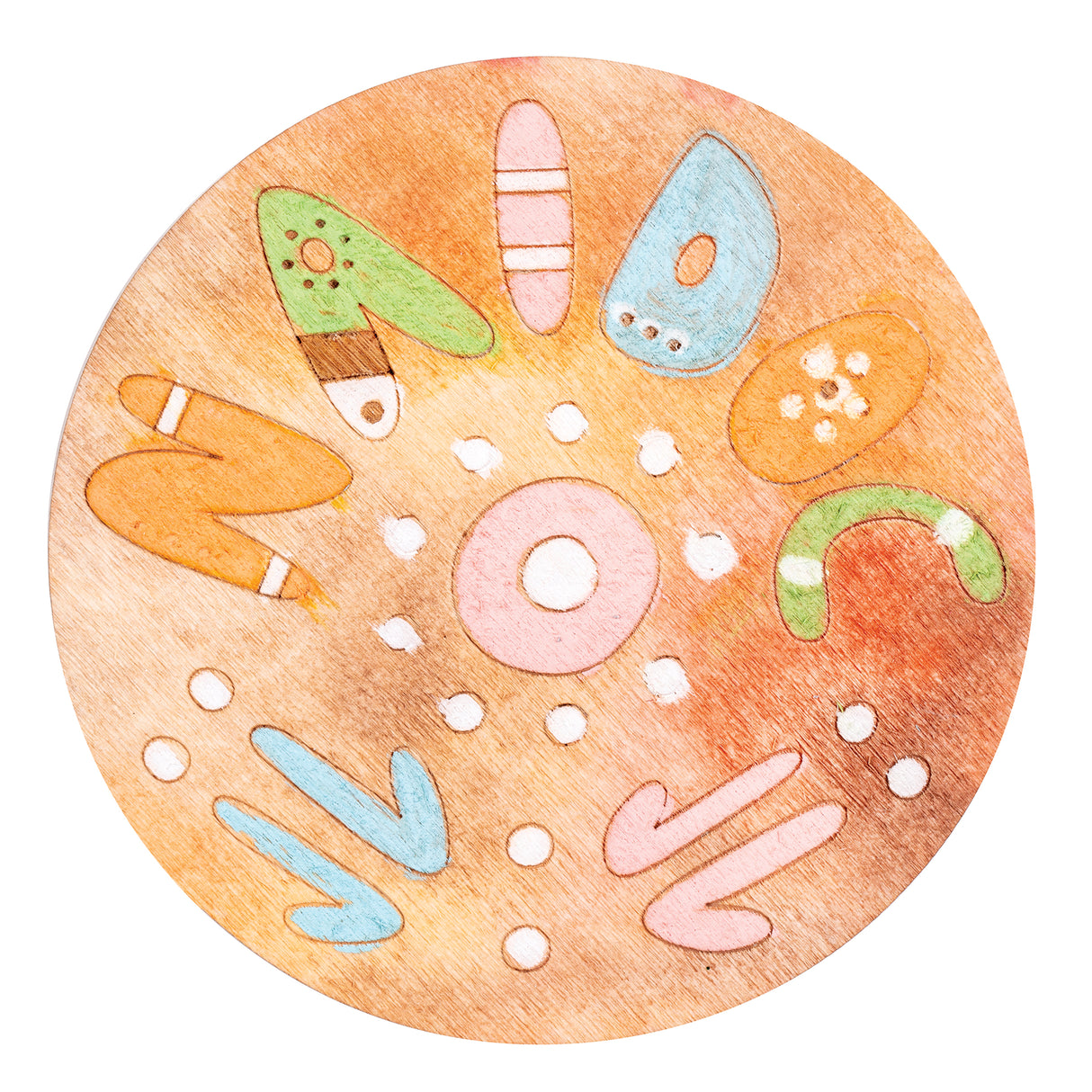 Circular wooden coaster featuring a colourful Indigenous-inspired design with hand-drawn illustrations of rockets, boomerangs, a donut shape, and natural forms in pastel green, blue, pink, and orange tones on a warm timber background with white dot details radiating from the centre.
