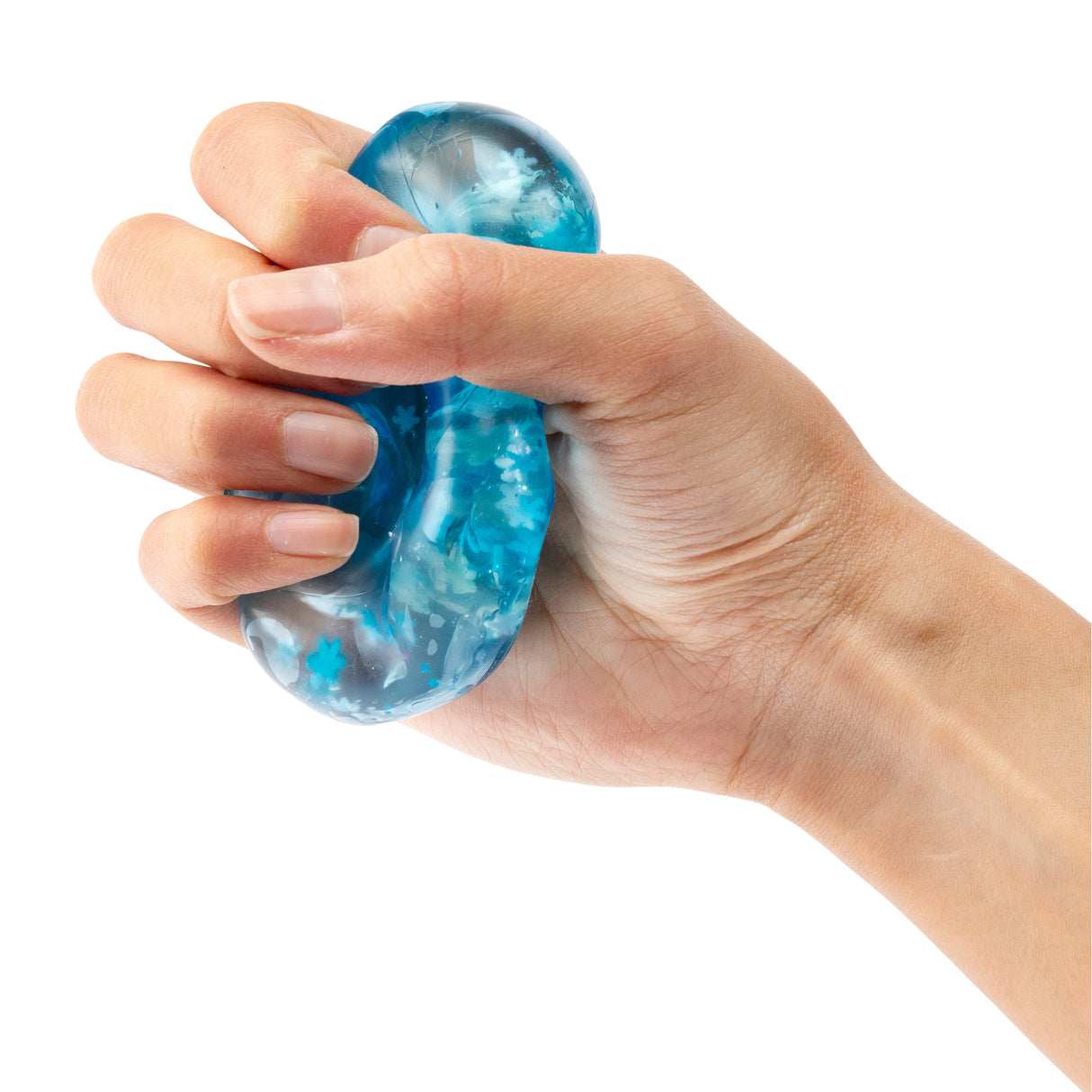Hand squeezing a translucent blue Sensory Sprouts Jelly Cube filled with swirling turquoise and white patterns and small confetti pieces. The squishy, gel-filled sensory toy demonstrates its flexible, tactile texture as fingers compress the smooth, dome-shaped cube against a white background.