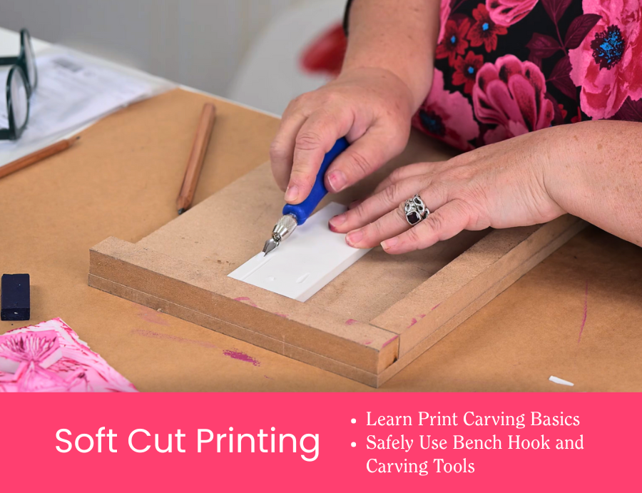 Zart Education PL The Essentials of Printing – A close-up, top-down view of a soft cut printing demonstration showing hands using a lino-style carving tool to carve into a white soft-cut block secured on a wooden bench hook. Surrounding the workspace are pencils, reference prints and tools on a kraft paper surface. A pink banner along the bottom includes the text: “Soft Cut Printing – Learn Print Carving Basics · Safely Use Bench Hook and Carving Tools.”