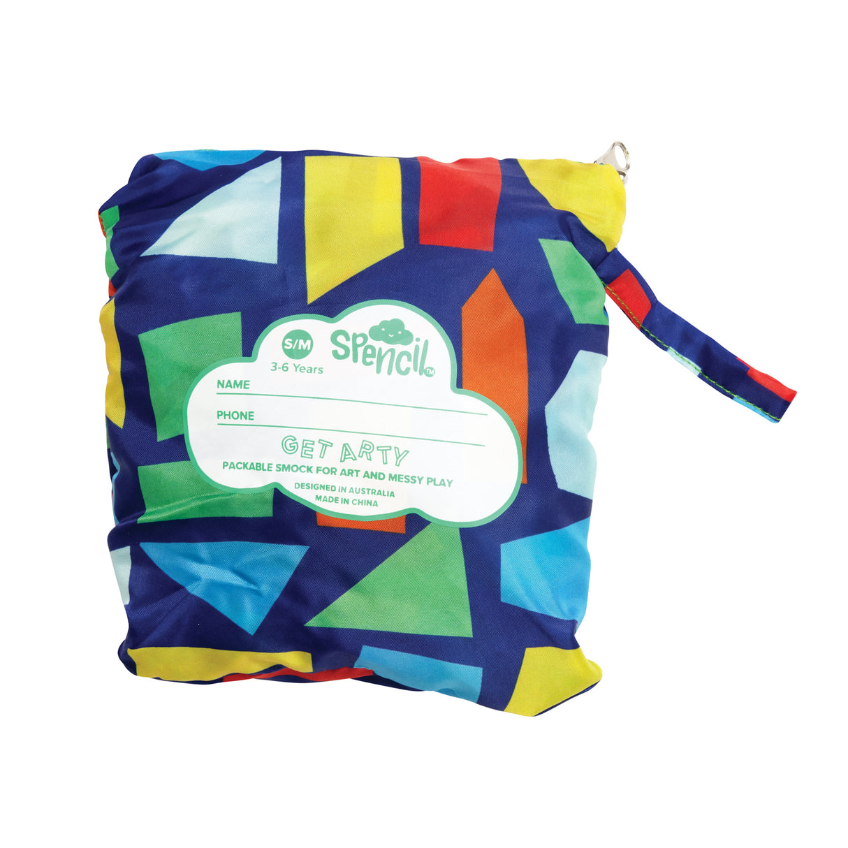 Spencil Art Smock in size S/M features a navy blue fabric with vibrant geometric shapes in yellow, red, orange, green, and light blue. The folded smock displays a white cloud-shaped label reading GET ARTY PACKABLE SMOCK FOR ART AND MESSY PLAY, with name and phone fields. A striped carry strap is attached.
