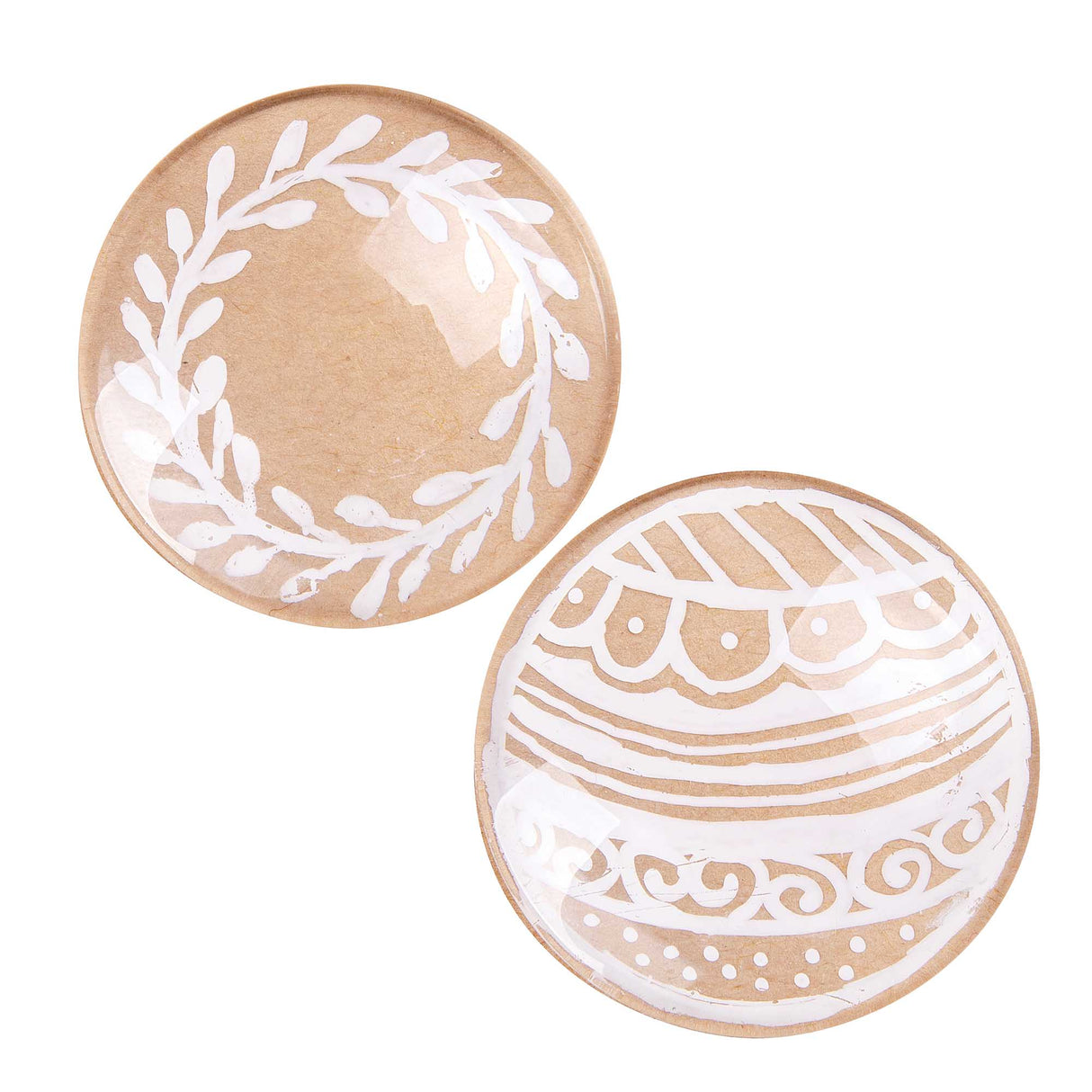 Two round glass dome stones showing Zart Gel Pen White artwork on natural kraft paper backing: one decorated with a delicate leaf wreath outline, the other with a bauble-style pattern of scalloped bands, dotted borders and swirling lines, all rendered in crisp white pen strokes.