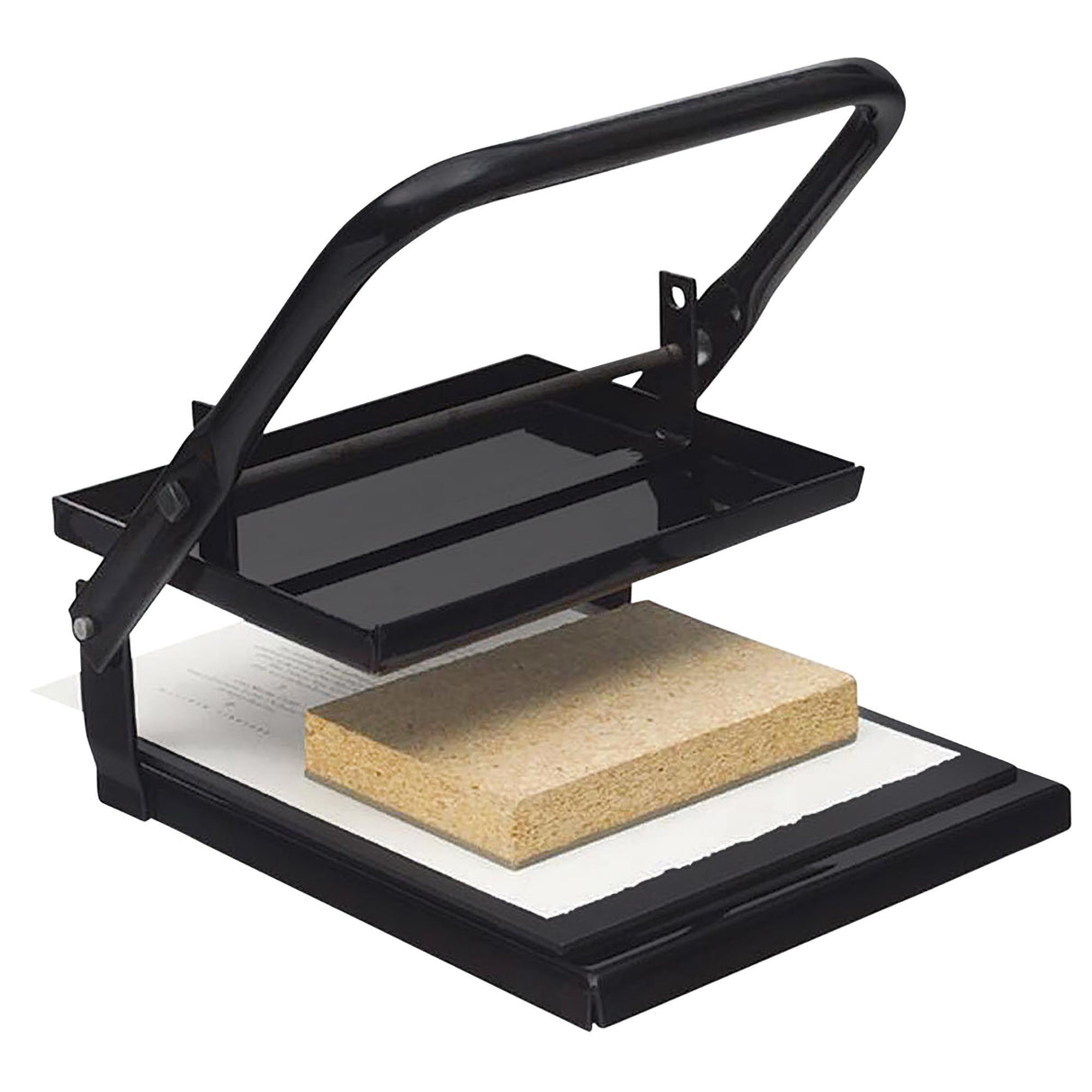 A black metal relief printing press with a hinged lever arm, shown open and ready for use. A rectangular lino block rests on white paper atop the flat base plate. The press applies even pressure for clean, consistent printmaking results.