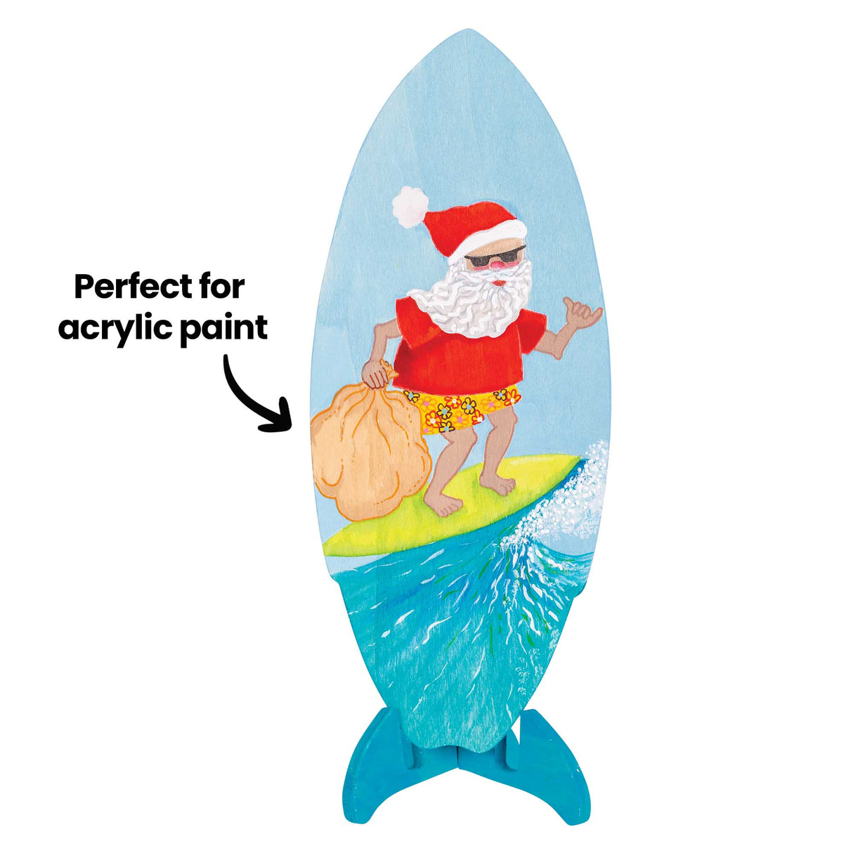 Painted wooden surfboard on a stand featuring a Santa character surfing a wave, holding a sack. Annotation text reads “Perfect for acrylic paint” with an arrow pointing to the board surface.