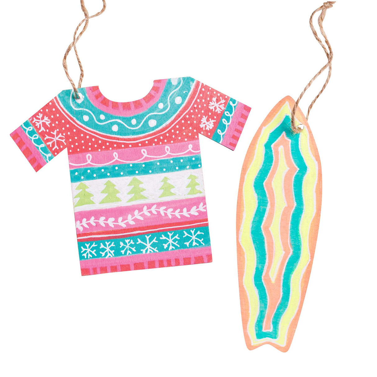 Two Zart Wooden Australian Summer Shapes hung on jute string, hand-painted as sample ornaments: a Christmas jumper t-shirt shape decorated in a festive fair-isle style with snowflakes, dotted trees and swirled patterns in pink, teal and red, and a surfboard shape striped in coral, teal and yellow.