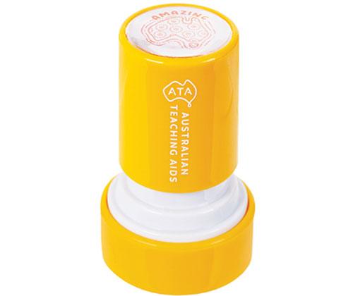 Bright yellow cylindrical Country Connections Stamp with white base and top lid, featuring Australian Fascinating Acos branding on the side and an intricate Aboriginal-inspired maze pattern design visible on the circular stamp surface.