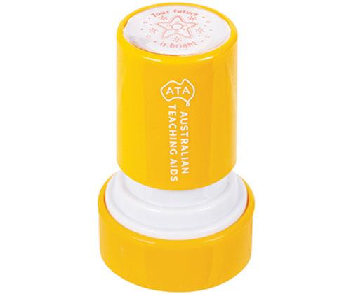 Bright yellow Country Connections self-inking stamp with white text reading "Australian Teaching Aids" and ATA logo. The circular stamp top displays a red outline illustration showing a farmyard scene with barn, tractor, sheep, chickens, and farm animals. Compact educational stamping tool for classroom activities.