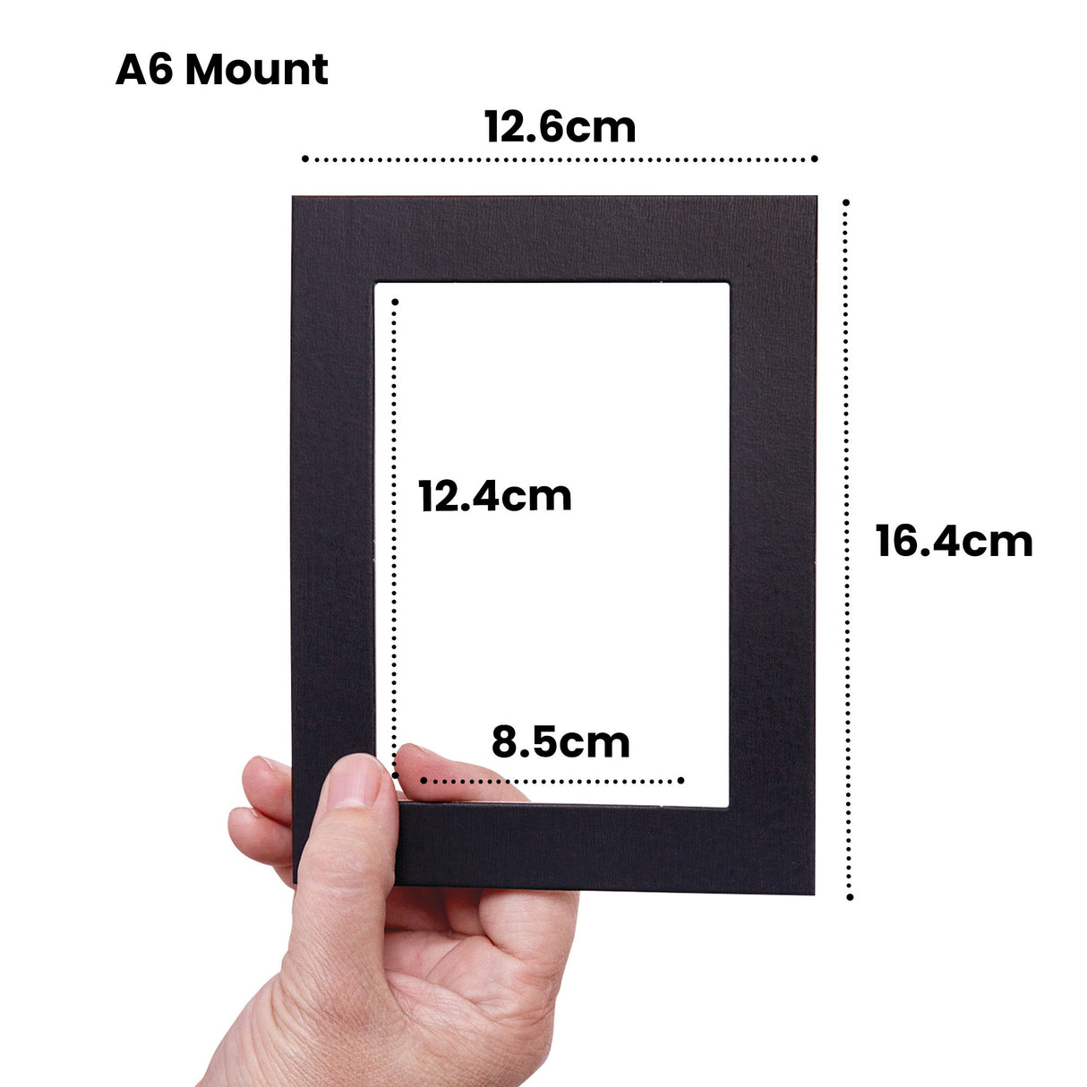 Hand holding a black A6 Mount with white rectangular window aperture, displaying measurement annotations: 12.6cm width at top, 16.4cm height on right side, 12.4cm inner window height, and 8.5cm inner window width, demonstrating the pre-cut mount's dimensions and proportions.