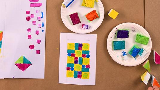 Overhead view of Zart Education On Demand lesson Tangram Mini Quilt Stamped Artworks Inspired by Emily Van Hoff by Dee Zabel. Image shows colourful geometric foam stamps and student prints featuring repeated shapes and bright colours, reflecting quilt-inspired pattern-making and stamping techniques.