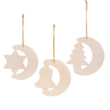 Three plain Zart Wooden Christmas Shapes hang by gold cord: a crescent moon with a star cut-out, a crescent moon with a bell cut-out, and a crescent moon with a tree cut-out. Each shows the natural plywood finish, ready for painting or decorating.
