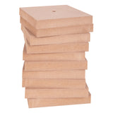 Zart Wooden Bases stacked in a tall pile, each a square block in natural pale wood with a visible pre-drilled hole centred in the top piece. The stack shows the flat, even thickness of each base and the raw MDF grain along the edges.
