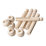 A scattered arrangement of Zart Wooden Peg and Stand pieces in natural, unpainted timber. Rounded ball-topped pegs with a slotted centre lie alongside separate ring-shaped stands, showing the plain components before decorating and assembly.