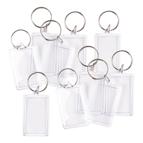 Ten Zart Rectangle Key Ring Tags scattered across a white background. Each tag consists of a clear rectangular plastic frame with a silver metal split ring attached at the top. The inserts are blank and undecorated, showing the transparent plastic casing from various angles.