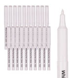 Ten White Perma Pen 1.0mm markers arranged in a row with translucent caps removed, displaying their pointed applicator tips. One pen stands upright on the right showing the full barrel with White Perma Pen branding. Made in Poland text visible on barrel.