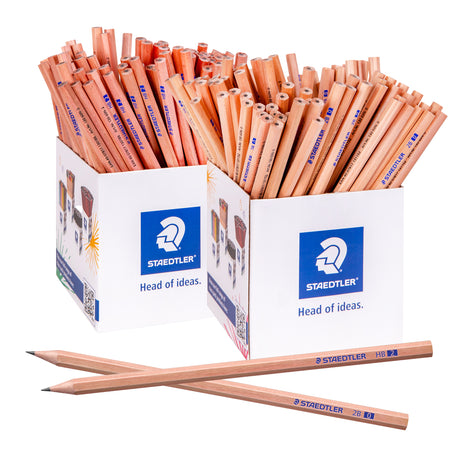 Two Staedtler natural graphite pencils crossed at the front, one marked HB and one marked 2B, both with a natural unpainted wood finish and sharpened, pointed tips. Two stacks of further pencils stand upright behind them, packed closely together in a fan-like spread.