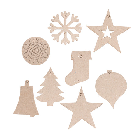 A flat lay of individual unpainted Zart Papier-mache Christmas decorations in natural kraft brown, including a snowflake, a circular snowflake motif, an open star, a bell, a Christmas tree, a stocking, a solid star, and a bauble, each with a small hanging hole.