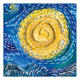 A miniature square canvas artwork features a swirling yellow spiral set against a rich blue background. Thick, textured paint creates raised ridges, while short white dash marks add movement across the surface, highlighting the canvas weave beneath.