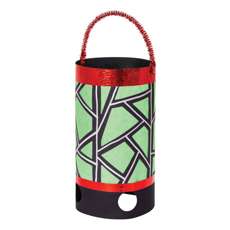 A decorated Zart Giant Lantern in cylindrical black card, wrapped in green tissue paper with a hand-drawn black and white geometric line pattern. Metallic red foil trims the top and bottom edges, and a sparkly red pipe cleaner forms the carry handle.