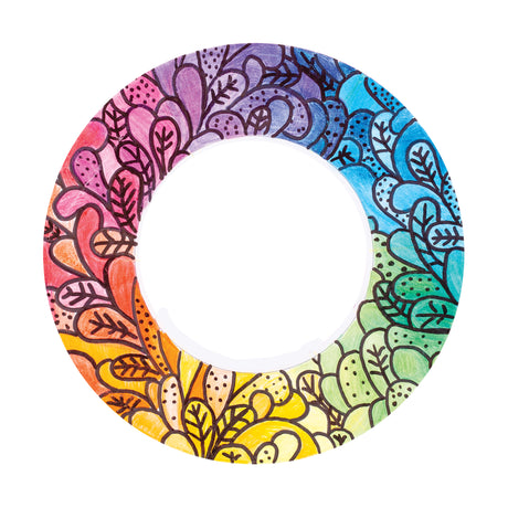 A hand-coloured sample made using a Zart ColourMe Wreath, filled in with a rainbow gradient from pink through purple, blue, green and yellow. The pre-printed leaf and dot pattern is traced in black marker, with colour blended smoothly around the full circle.