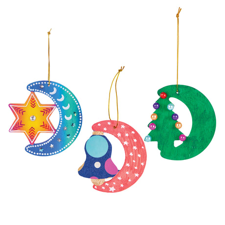 Three decorated ornaments made using Zart Wooden Christmas Shapes. A blue and orange crescent moon with a painted star and gem centre, a red and navy crescent moon with a bell design, and a green crescent moon with a beaded Christmas tree, each on a gold cord.