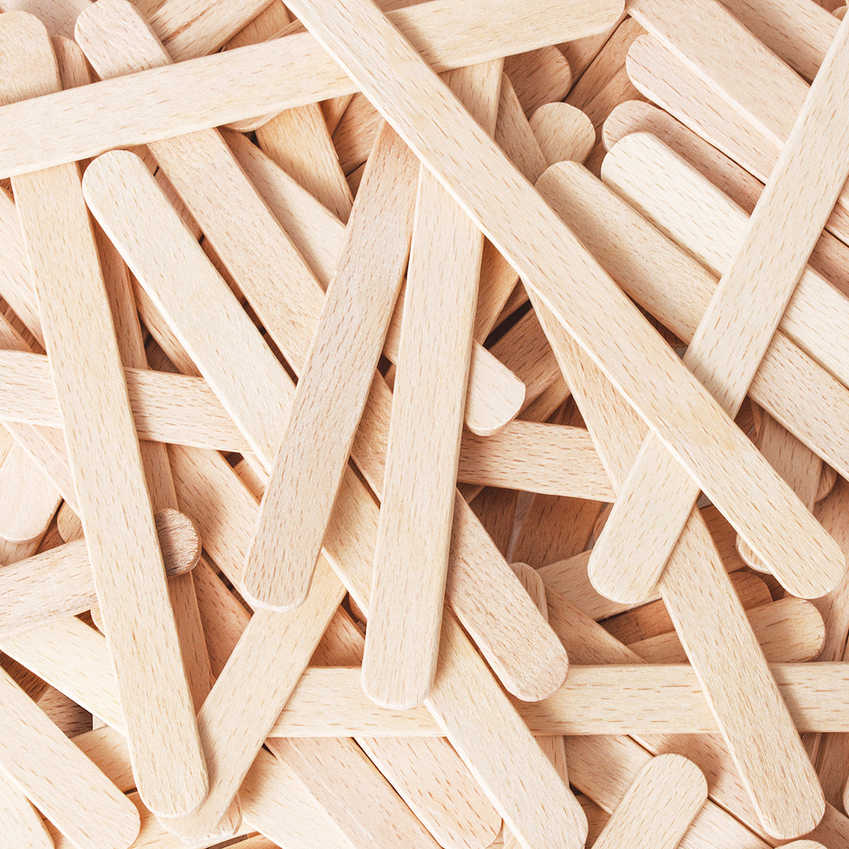 Close-up view of overlapping natural wooden craft sticks arranged in a layered pattern, highlighting the smooth finish, rounded edges and visible pale wood grain. The image shows consistent thickness and cleanly cut ends, emphasising the quality and texture of the timber.