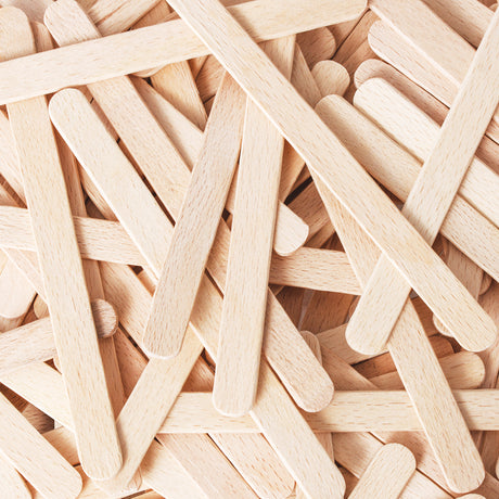 Close-up view of overlapping natural wooden craft sticks arranged in a layered pattern, highlighting the smooth finish, rounded edges and visible pale wood grain. The image shows consistent thickness and cleanly cut ends, emphasising the quality and texture of the timber.