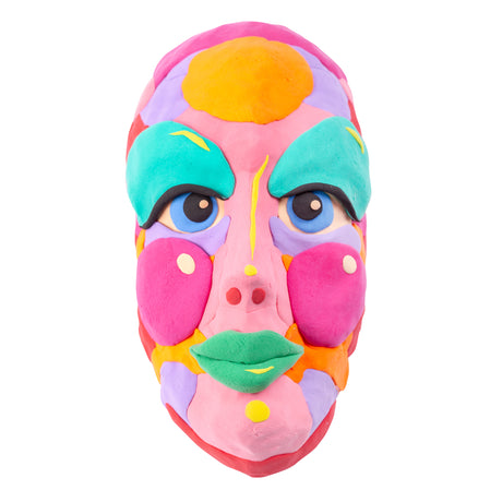 Vibrant three-dimensional female face mask sculpture created with modelling materials in bold colours including pink, teal, yellow, orange and purple. Features exaggerated facial features with blue eyes, turquoise eyebrows, pink cheeks, and a green mouth, demonstrating creative layering techniques and colour blocking against a white background.