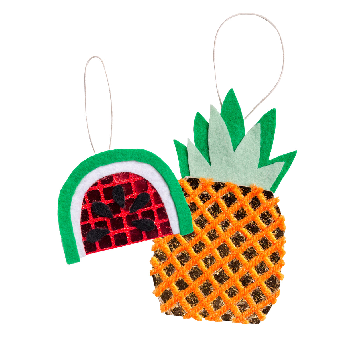 Two hanging decorations made with Zart Mirror Pattern Felt sheets in geometric checks: a watermelon shape with green felt rind, white pith, and reflective red-and-black mirrored felt centre, and a pineapple with sage and green felt leaves atop a golden mirrored body wrapped in orange yarn.