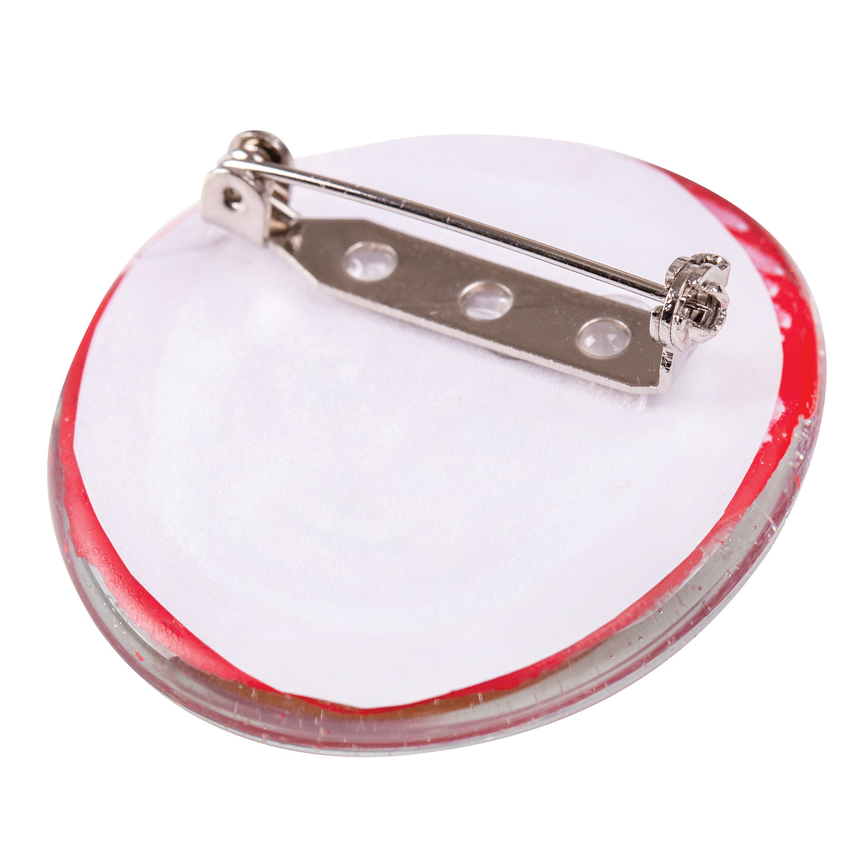 A Zart Brooch Back glued to the back of a round red-rimmed craft piece, shown at an angle with the flat bar and pin visible against white backing paper, demonstrating how the fitting sits flush once attached to a finished brooch.