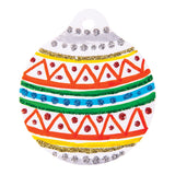 A round bauble-shaped card decorated as a Kindyglitz sample artwork, with alternating bands of silver, gold, green and blue glitter dots and lines layered over hand-painted stripes and a repeating orange triangle pattern in red glitter dots, on a white card background.