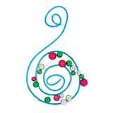 A decorative sculpture made from blue Craft Coloured Wire, shaped into a flowing spiral form and threaded with colourful beads in red, green, white, and pink. Demonstrates the wire's flexibility and suitability for jewellery making and sculptural design projects.