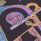 A close-up detail of a sample artwork drawn in POSCA Metallic Markers on black paper, showing a pink face playing a silver flute, framed by a purple arch with yellow trim. Orange, gold and blue shapes are visible at the edges.
