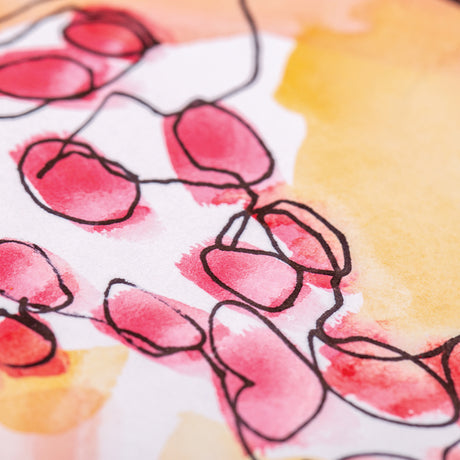 Close-up of artwork drawn with a black permanent pen on white paper, showing loose black linework over red and yellow watercolour washes to demonstrate ink clarity over painted surfaces.