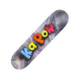 Skateboard deck displayed diagonally on a white background, featuring graffiti-style lettering spelling Kapow in bright colours. The design includes halftone dot patterns, stars, and spray paint textures, with handwritten-style signatures and graphic details across the board.