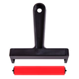 Rubber roller separated into two parts: black plastic handle and frame positioned above, with the red rubber roller cylinder removed below. The detachable design highlights easy maintenance and thorough cleaning between printmaking or painting sessions.