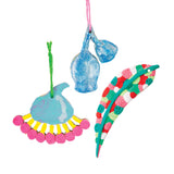 Three Zart Wooden Australian Gum Hangers decorated as sample artworks: a metallic blue gum nut cluster hung on pink cord, a turquoise gum blossom with marbled paint and pink-and-yellow dotted spokes on green cord, and a curved leaf covered in colourful clay-like dotted patterning in red, green, pink and white.