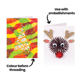 Two decorated tree samples made using Zart Christmas Cut-out Threading Cards. One shows orange and green yarn threaded through a tree shape over a colourful printed background with a gold star; text reads "Colour before threading". The other shows a yarn-threaded reindeer face with cardboard antlers, felt ears and a pom-pom nose, labelled "Use with embellishments".