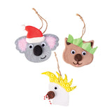 Three decorated hangers made using Zart Wooden Australian Animal Hangers: a grey koala in a red and white Santa hat, a brown wombat with green paper ears, and a white cockatoo with a yellow crest holding tiny candy canes. Joggle Eyes and jute loops finish each piece.