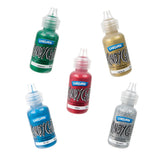 Five Kindyglitz glue bottles arranged at scattered angles against a plain white background, each showing its sparkling glitter colour through the clear plastic bottle: green, gold, red, blue and silver, labelled with matching colour names on the front.