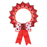 A decorated sample made using a Zart ColourMe Wreath, with red and gold glitter paper petals layered around the printed pattern and a red-and-white polka dot bow with glittery centre and ribbon tails. The finished piece resembles a festive rosette wreath.