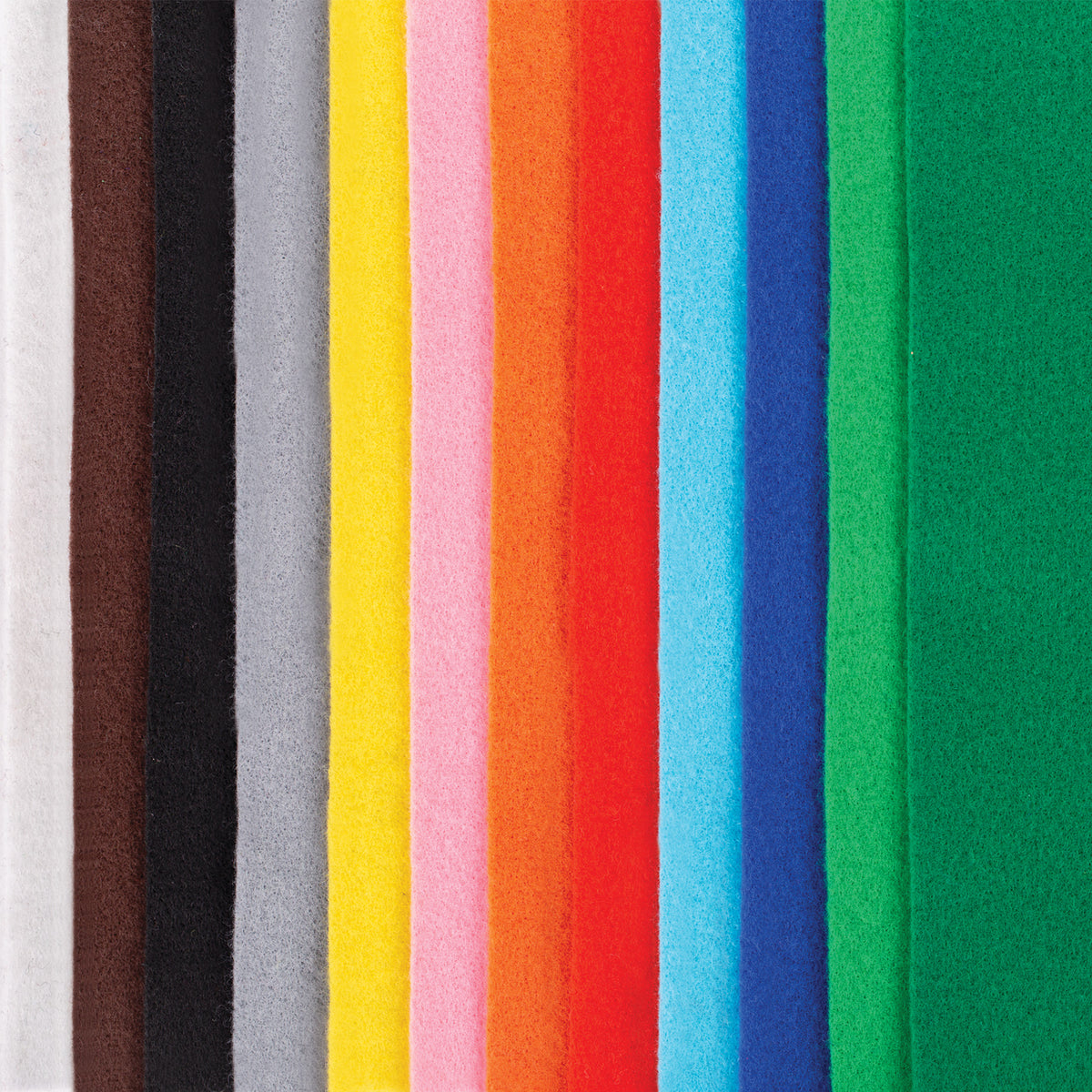 A close-up of Zart felt sheets standing edge to edge, showing the colour range side by side: white, brown, black, grey, yellow, pink, orange, red, sky blue, navy and two shades of green. Each sheet has a soft, matte, slightly fuzzy texture typical of felt.
