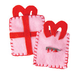 Two felt Christmas present brooches shown front and back: the front view shows pink felt with a red ribbon cross and bow in blanket stitch, while the back view reveals a Zart Brooch Back stitched through its holes with red thread beneath the matching red bow shape.