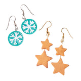 Two pairs of handmade earrings shown as sample artworks using Zart Jewellery Findings. The left pair features round teal discs with white painted snowflake designs, hung on silver shepherd hooks. The right pair features two terracotta-toned star shapes linked in a drop formation, suspended from gold shepherd hook findings.