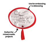 Embossed oval plaque bordered in red felt with a tassel attached below. Raised text reads, Friendship is not a big thing Its a million little things. Decorative flowers and leaves surround the wording. Annotation states Use for embossing & debossing and Perfect for mixed media projects.