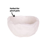 A small hand-formed bowl made from white air drying clay, with thick uneven walls, a rounded base and an irregular rim. The surface is textured with fingermarks and a soft matte finish. A black annotation reads "Perfect for pinch pots" with a curved arrow pointing into the bowl.