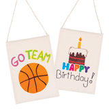 Two decorated Zart Calico Banners shown as sample artworks. The left banner features the text "GO TEAM" in multicoloured lettering above a painted orange basketball. The right banner displays a layered birthday cake with a lit candle, with "HAPPY" in multicoloured block letters and "Birthday!" in black script below.